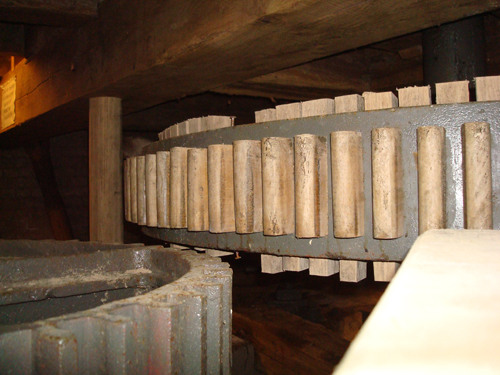 Wooden cogs of the track wheel and cast iron spur wheel